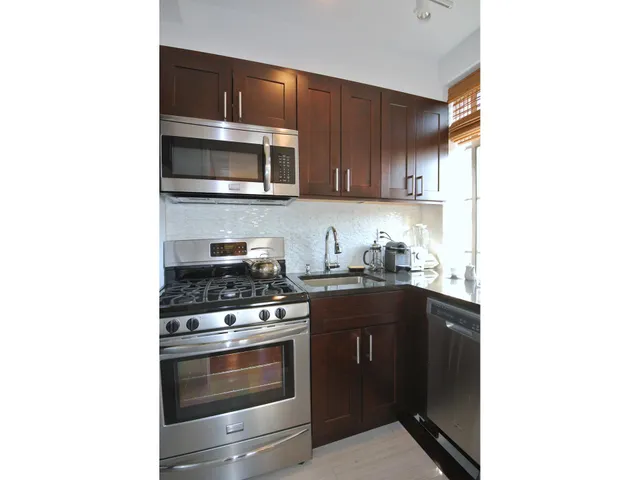 a kitchen with stainless steel appliances granite countertop a stove and a microwave