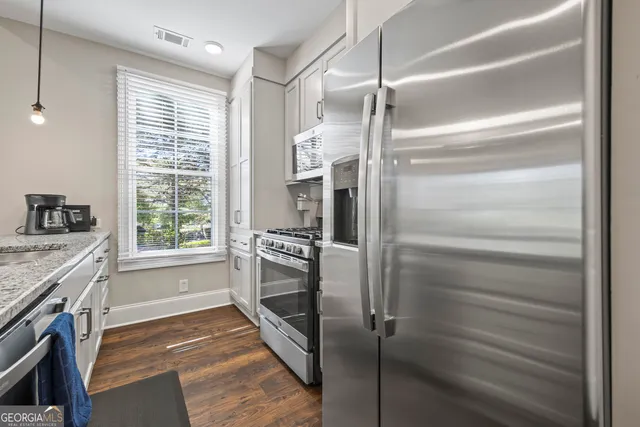 a kitchen with a refrigerator and white cabinets