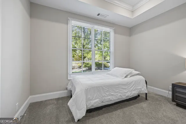 a bed sitting in a bedroom next to a window