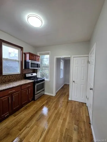 a large kitchen with cabinets and wooden floor