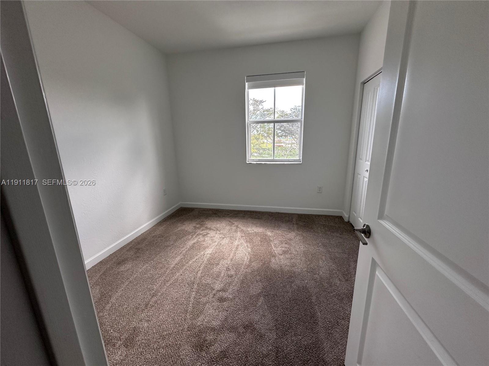 1884 Southeast 27th Street Homestead, FL 33035 - Photo 22 of 34 an empty room with windows
