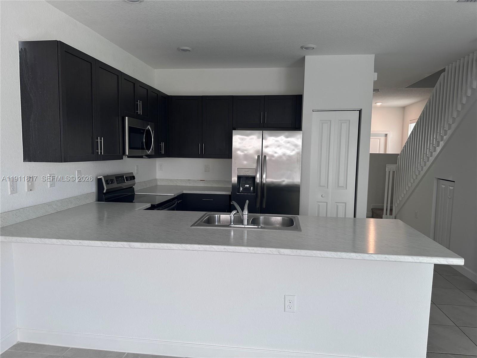 1884 Southeast 27th Street Homestead, FL 33035 - Photo 8 of 34 a kitchen with stainless steel appliances a sink and a refrigerator