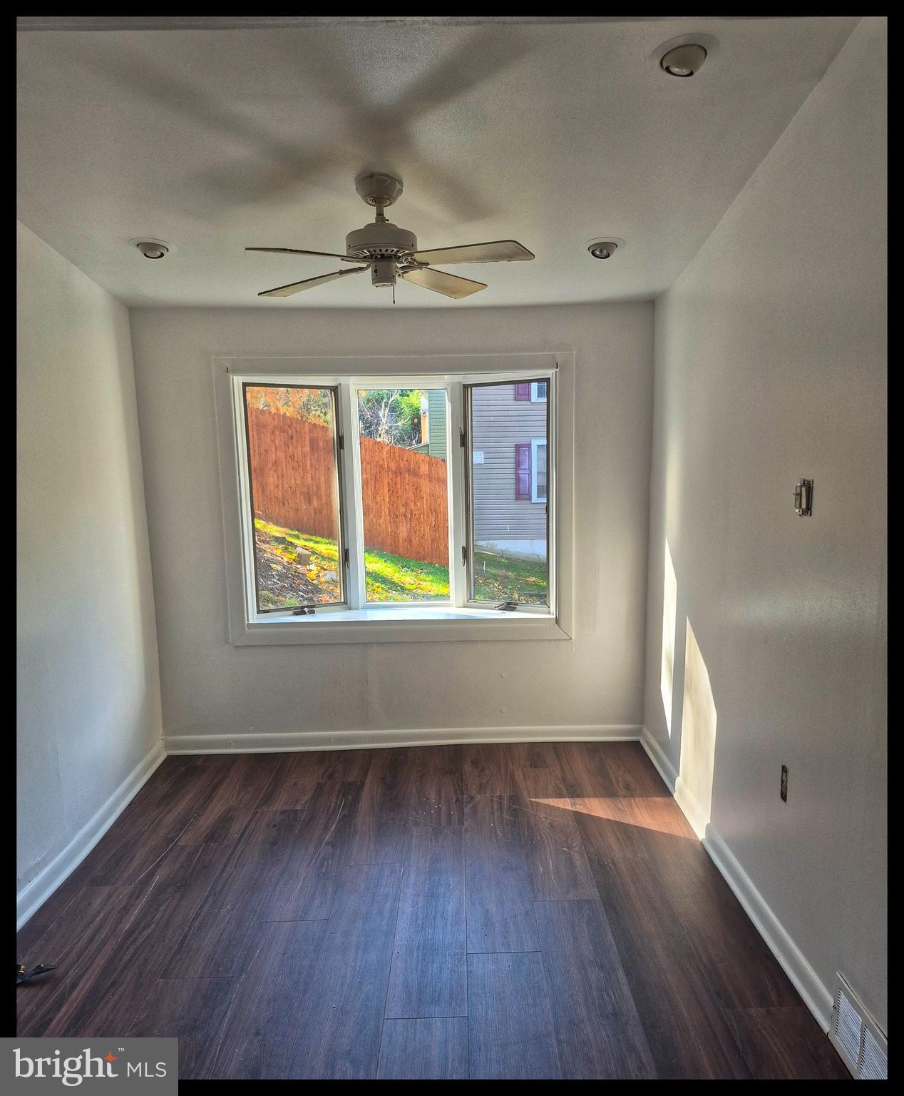 wooden floor in an empty room with a window