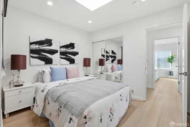 a spacious bedroom with a bed and a white couch