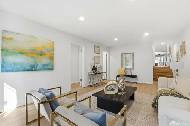 a living room with furniture a rug and white walls