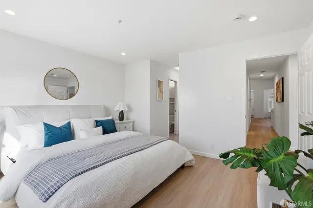 a bedroom with a bed and a potted plant