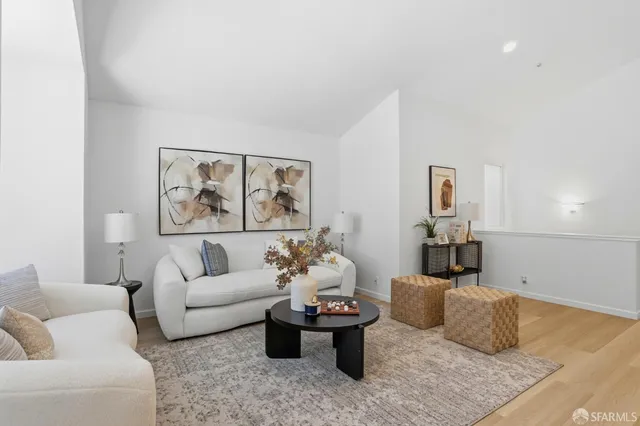 a living room with furniture and a painting on the wall