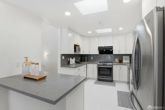 a kitchen with stainless steel appliances granite countertop a refrigerator sink and stove