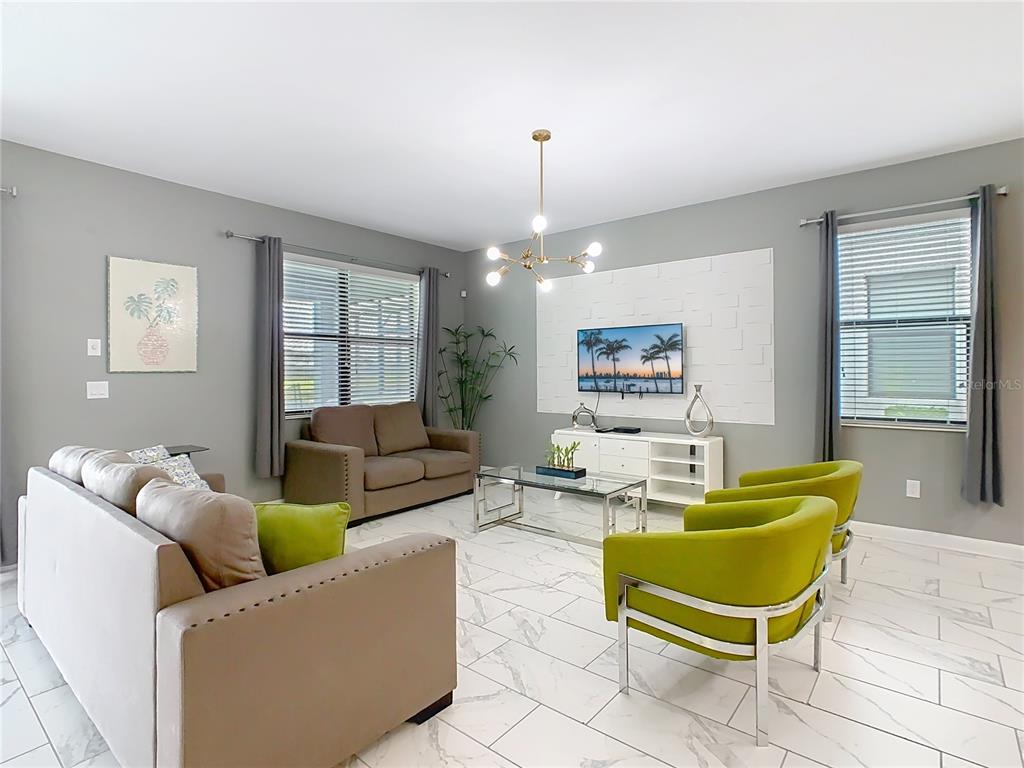 2925 Fable Street Kissimmee, FL 34746 - Photo 12 of 56 a living room with furniture and a chandelier