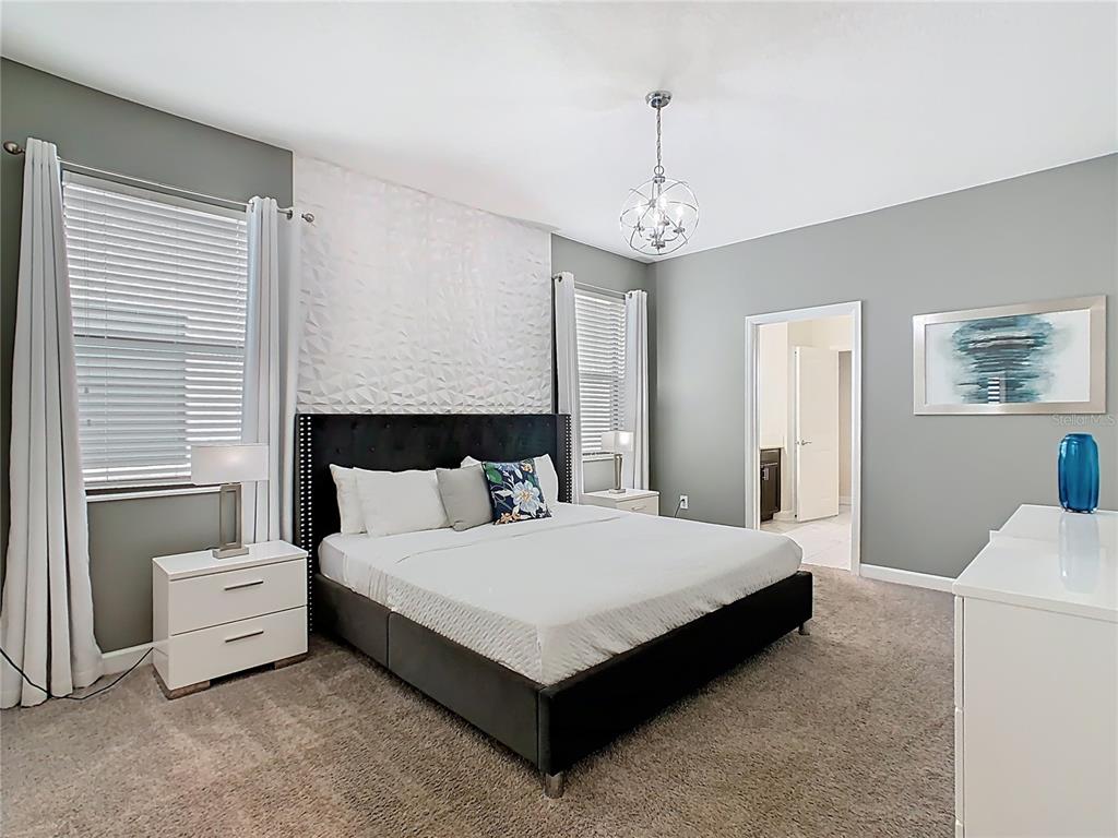 2925 Fable Street Kissimmee, FL 34746 - Photo 40 of 56 a spacious bedroom with a bed and a chandelier