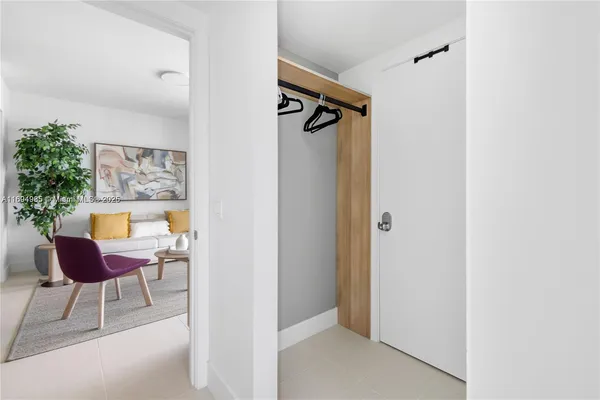 a view of a hallway with chairs and a potted plant