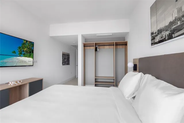 a bedroom with a bed and a flat screen tv