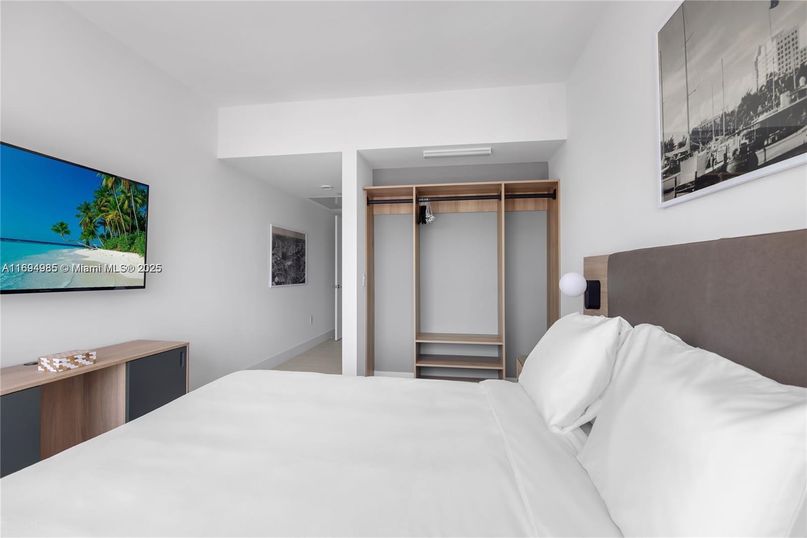 159 Northeast 6th Street, Unit 2916 Miami, FL 33132 - Photo 23 of 44 a bedroom with a bed and a flat screen tv