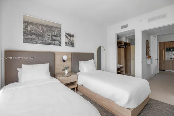 a bedroom with two beds and painting on the wall