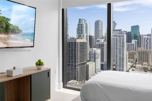 a bedroom with a balcony a bed and a painting on the wall