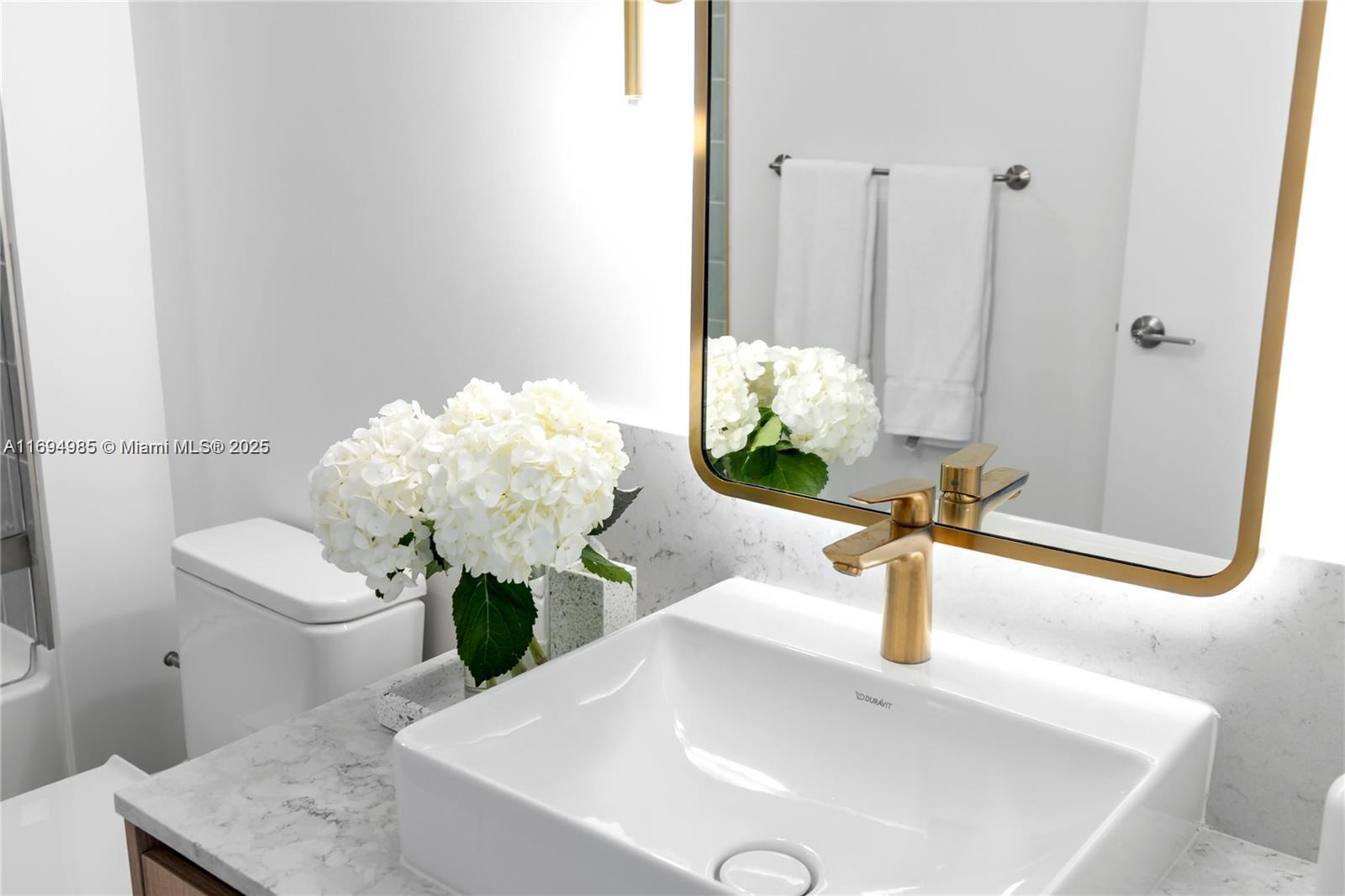 159 Northeast 6th Street, Unit 2916 Miami, FL 33132 - Photo 33 of 44 a bathroom with a sink a toilet and a mirror