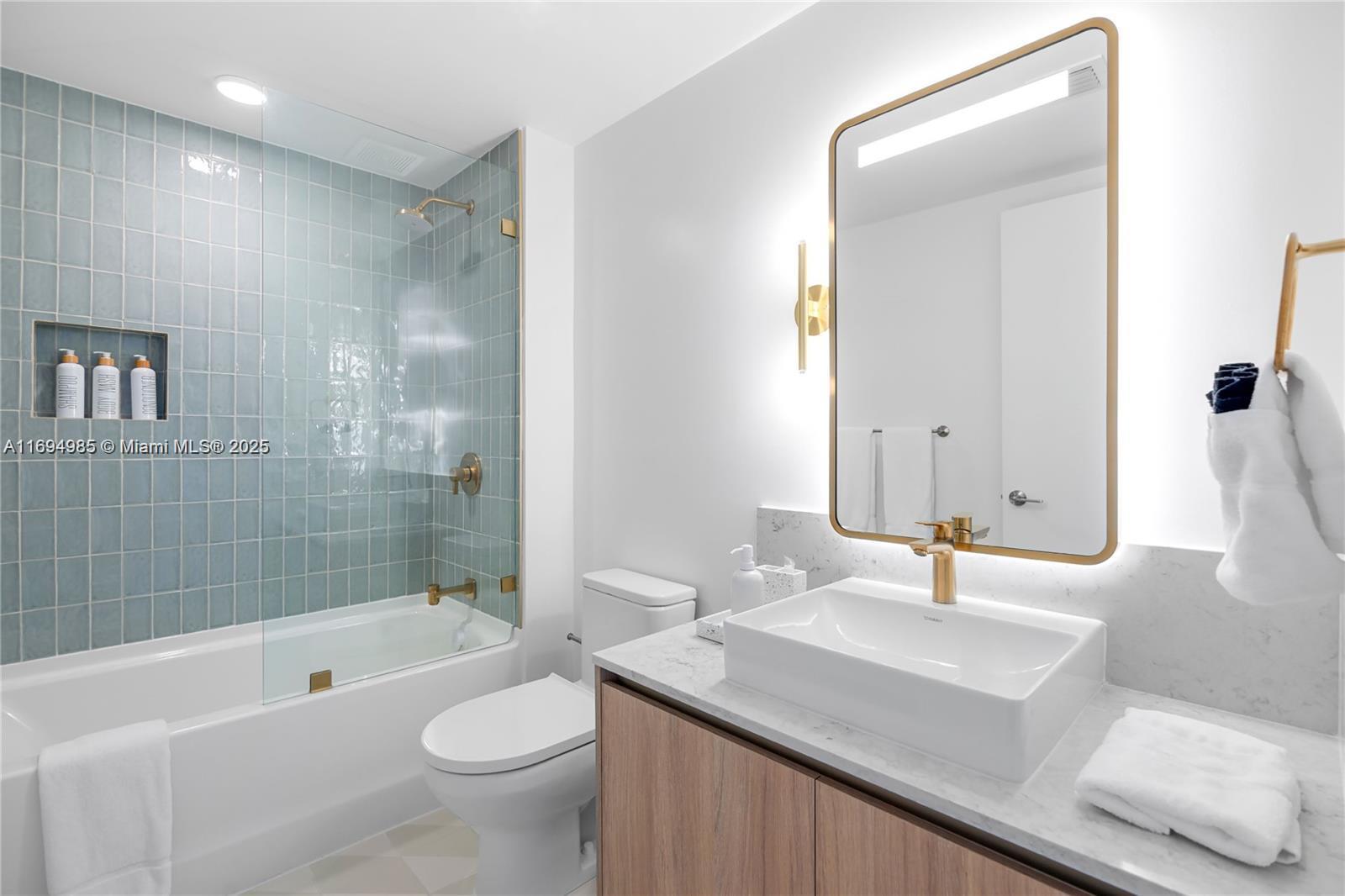 159 Northeast 6th Street, Unit 2916 Miami, FL 33132 - Photo 34 of 44 a bathroom with a sink a toilet a mirror and bathtub
