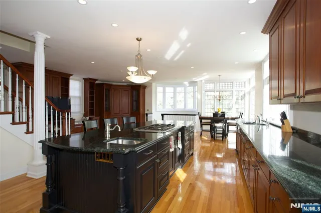 a kitchen with granite countertop a sink counter space and stainless steel appliances