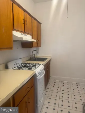 a kitchen with a sink a stove and cabinets