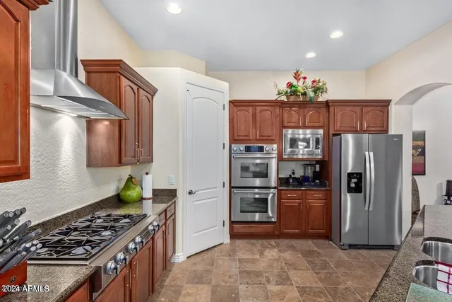 a kitchen with stainless steel appliances granite countertop a refrigerator and a stove