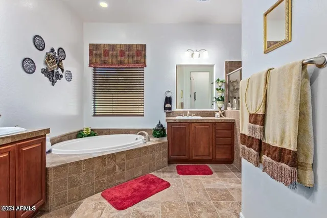 a bathroom with a tub sink and a mirror