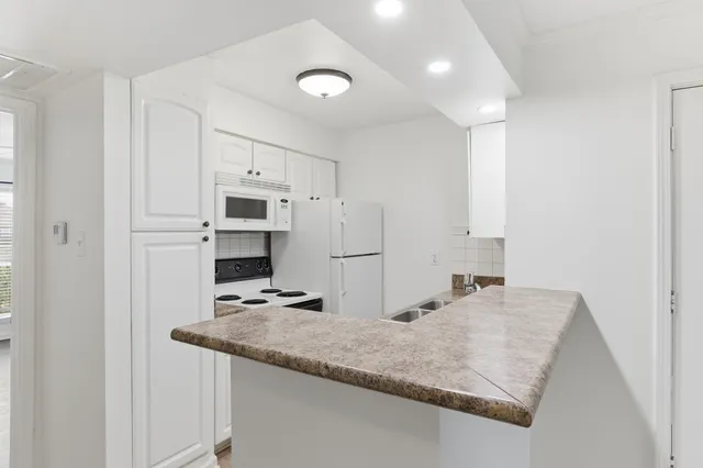 a kitchen with stainless steel appliances granite countertop a sink refrigerator and cabinets