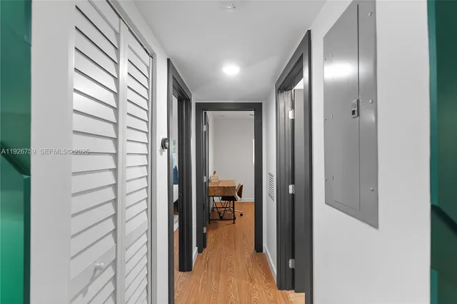a view of hallway with livingroom and wooden floor