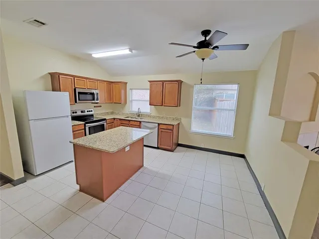 a kitchen with stainless steel appliances granite countertop a refrigerator and a stove top oven