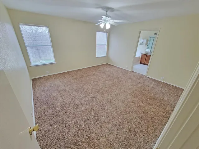 a view of a big room with wooden floor and a ceiling fan