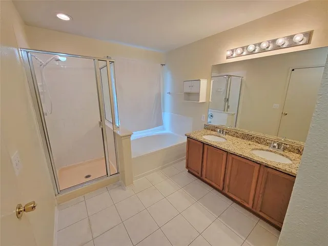 an empty room with a chandelier fan and windows