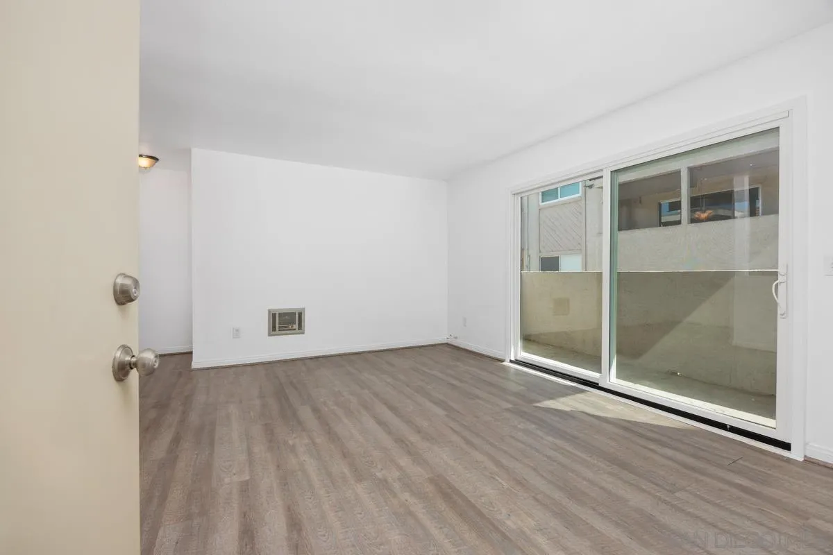 3431 Capalina Road, Unit 16 San Marcos, CA 92069 - Photo 6 of 17 an empty room with wooden floor and windows