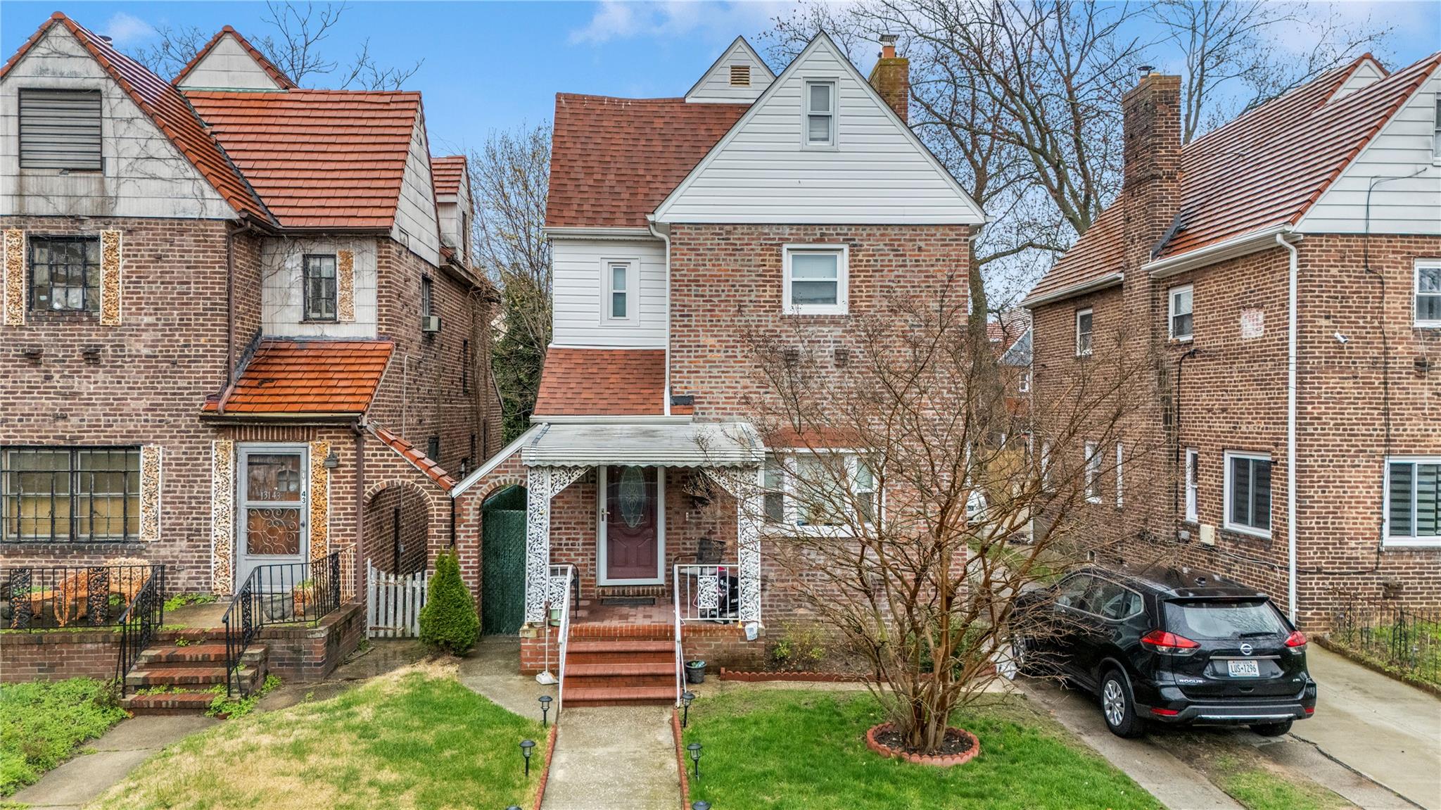 131-45 227th Street Queens, NY 11413 - Photo 1 of 1 View of property featuring brick siding and a front lawn