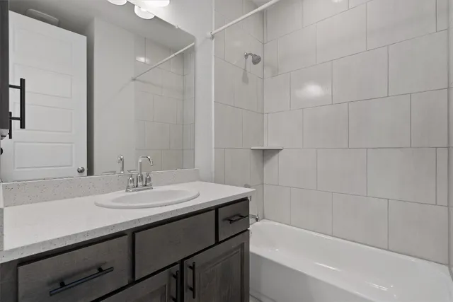 a bathroom with a sink double vanity granite tub shower and a mirror