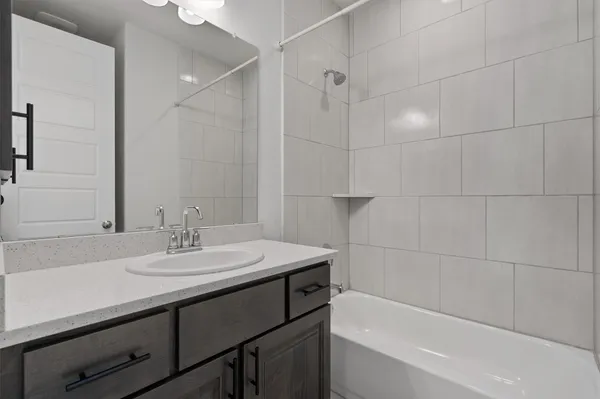 a bathroom with a sink double vanity granite tub shower and a mirror