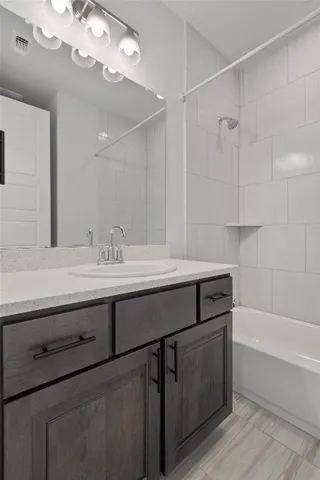 a bathroom with a sink a large mirror and a bathtub