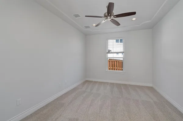 an empty room with a window and a ceiling fan