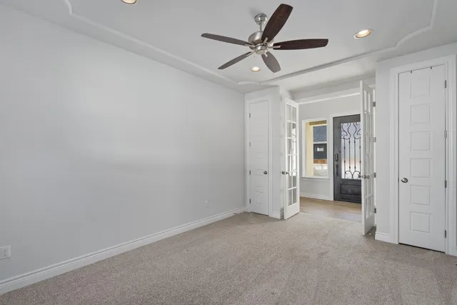 an empty room with a ceiling fan and window