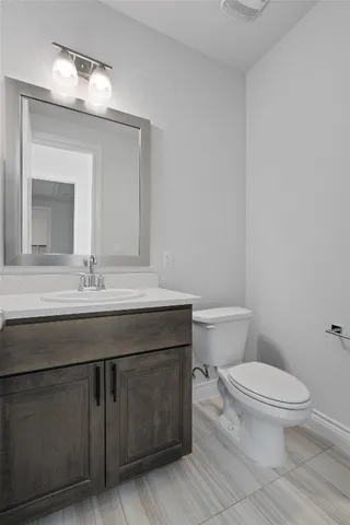 a bathroom with a granite countertop toilet sink and mirror