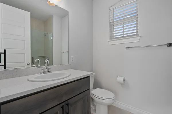 a bathroom with a sink a toilet and a mirror