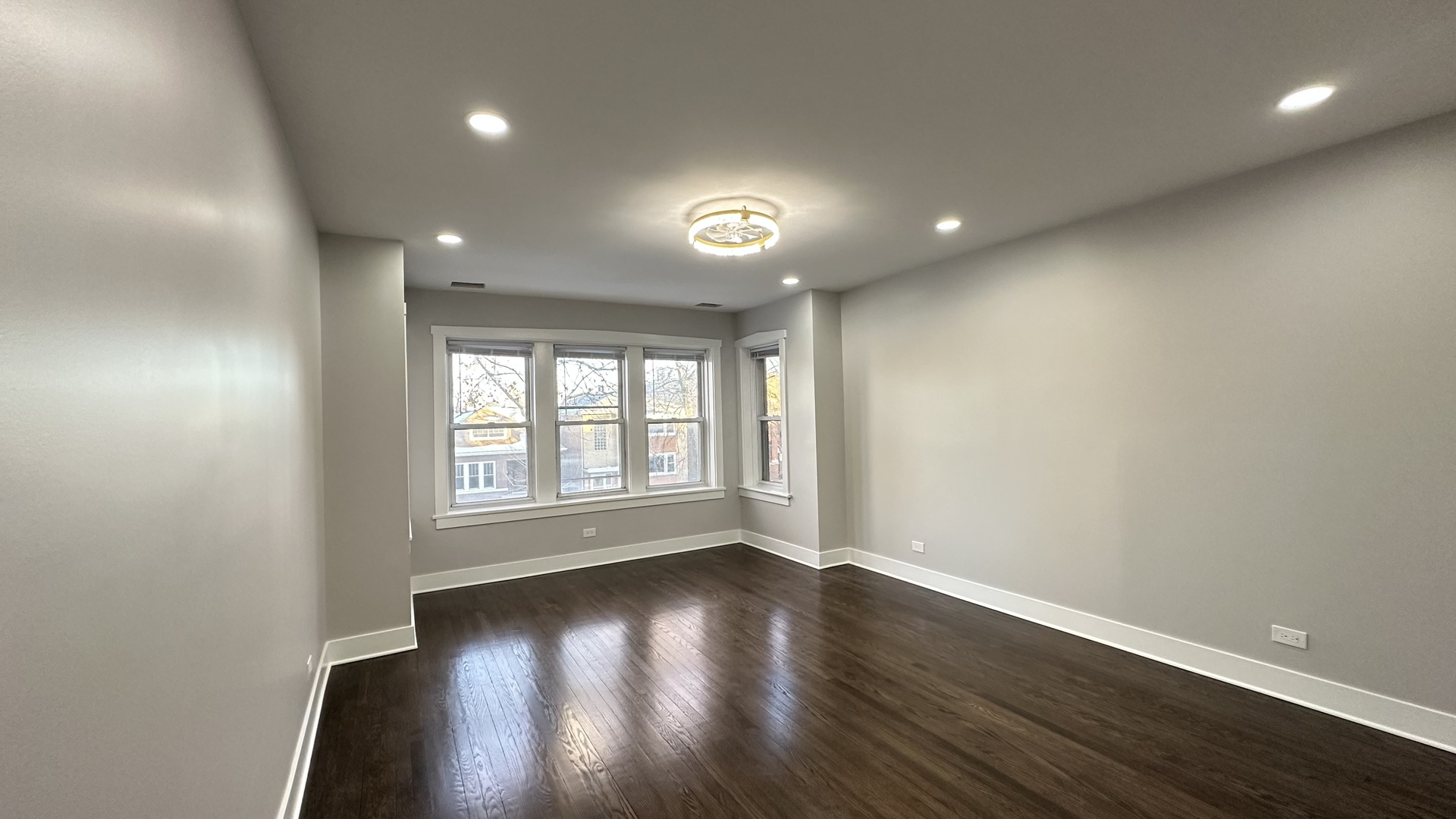 5224 North Bernard Street, Unit 1 Chicago, IL 60625 - Photo 2 of 13 an empty room with wooden floor and windows