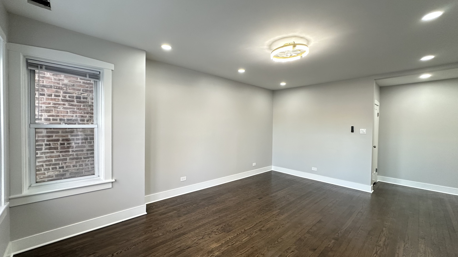 5224 North Bernard Street, Unit 1 Chicago, IL 60625 - Photo 3 of 13 a view of an empty room with wooden floor and a window