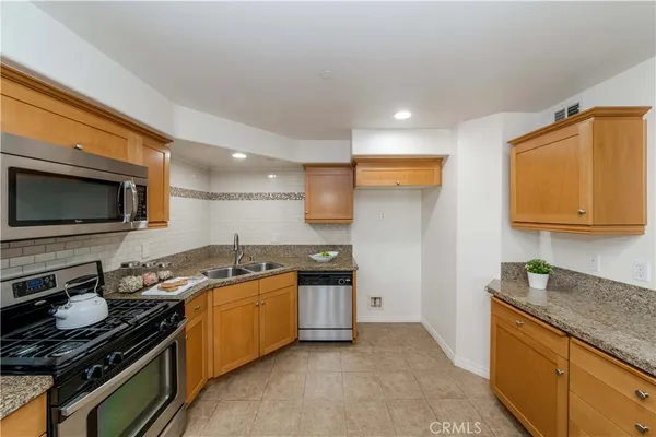a kitchen with stainless steel appliances granite countertop a stove and a sink
