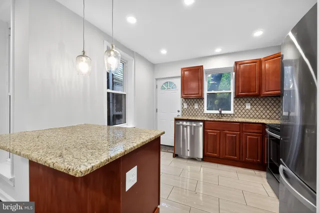 a kitchen with stainless steel appliances granite countertop a sink and stove