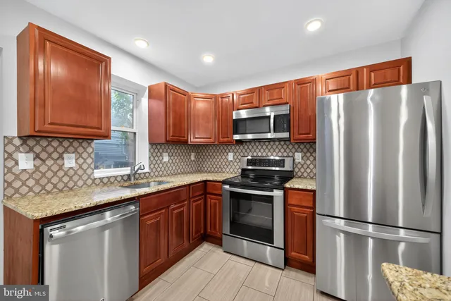 a kitchen with stainless steel appliances granite countertop a refrigerator stove microwave and sink