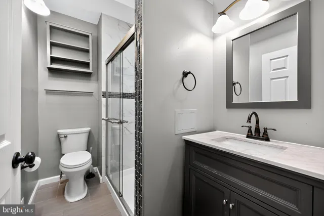 a bathroom with a toilet sink and mirror