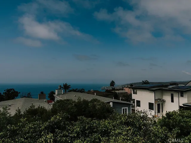 a backyard of a house with lots of green space and a lake view in back