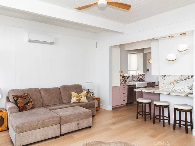 a living room with stainless steel appliances kitchen island granite countertop furniture and a couch