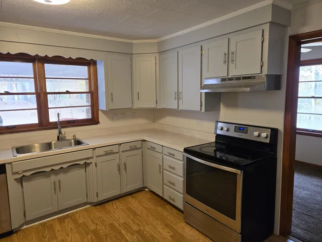 en empty room with windows and chandelier