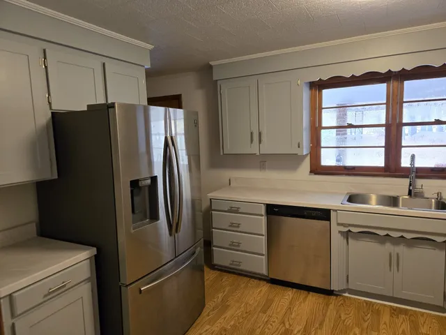 a view of an empty room with window and wooden floor