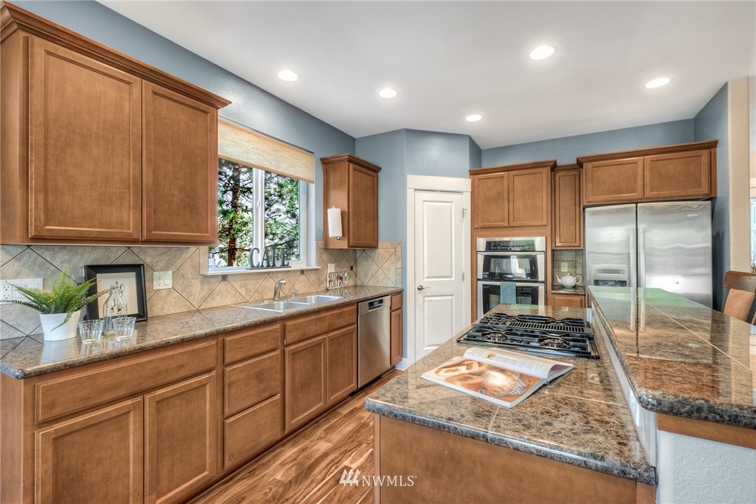 5236 Northeast 9th Place Renton, WA 98059 - Photo 8 of 27 a kitchen with stainless steel appliances granite countertop sink stove and refrigerator